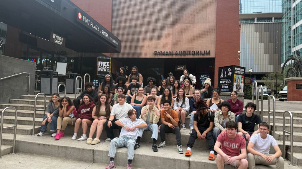 large group of teens sitting on the outdoor steps of the Ryman Auditorium in Nashville