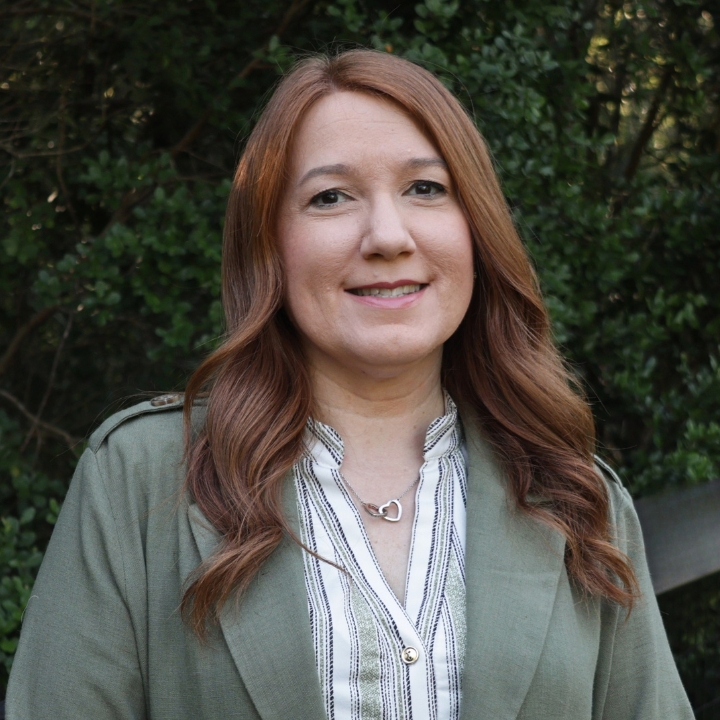 Jeanne Henry, Kaleidoscope Adventures team member, smiling outdoors in a green jacket.