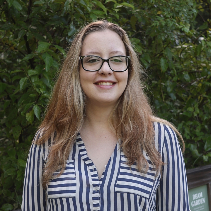 Laura Luttrell, Kaleidoscope Adventures team member, smiling outdoors in glasses and a blue-and-white striped blouse.