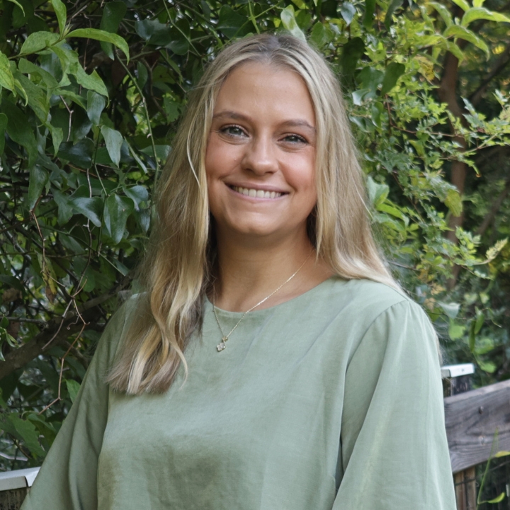 Delaney Langston, Kaleidoscope Adventures team member, smiling outdoors in a light green blouse.