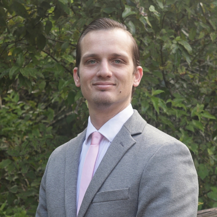 Steven Gross, Kaleidoscope Adventures team member, wearing a gray suit and light pink tie outdoors.