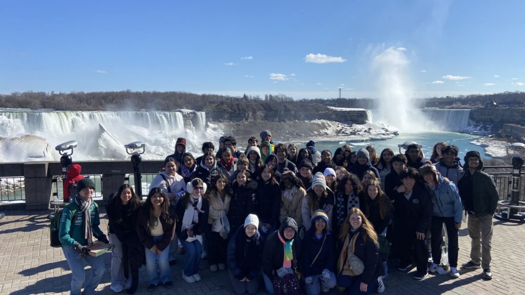 group of high school students posing in front of Niagara Falls for a photo