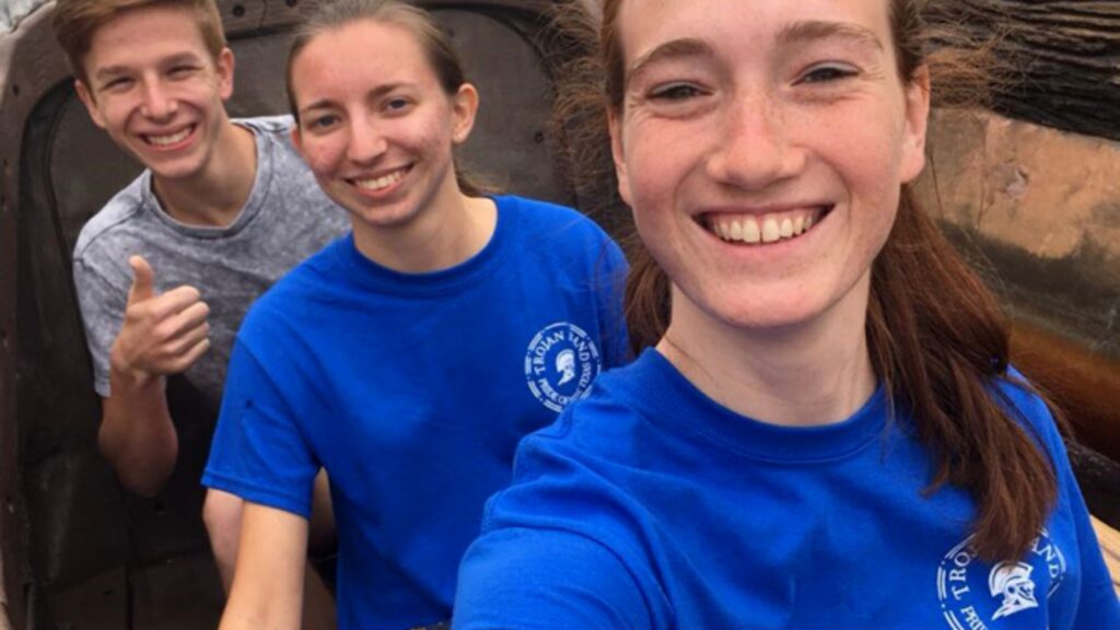 3 smiling teens wearing blue and gray t-shirts