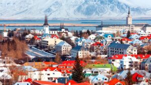 view overlooking city with red roofs and ocean in the background