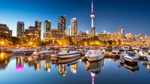 evening view of Toronto skyline featuring CN Tower and boats in foreground