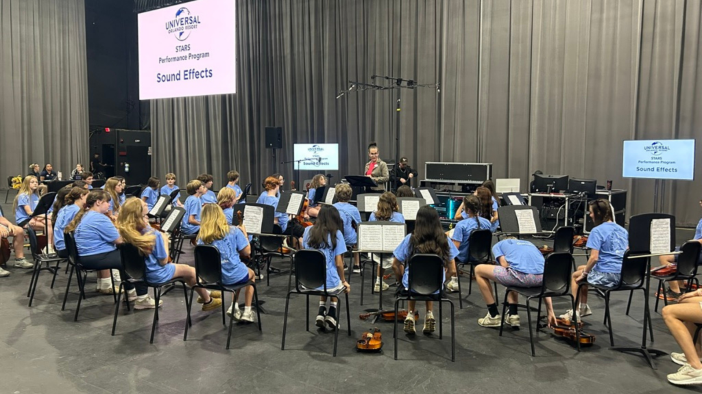 large group of students in blue shirts at a Universal Studios workshop