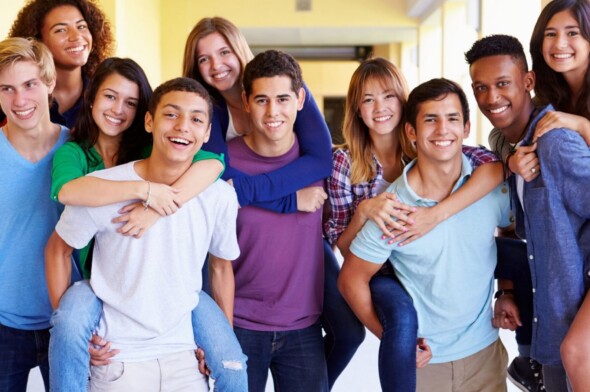 group of diverse teens gathered together and smiling for the camera