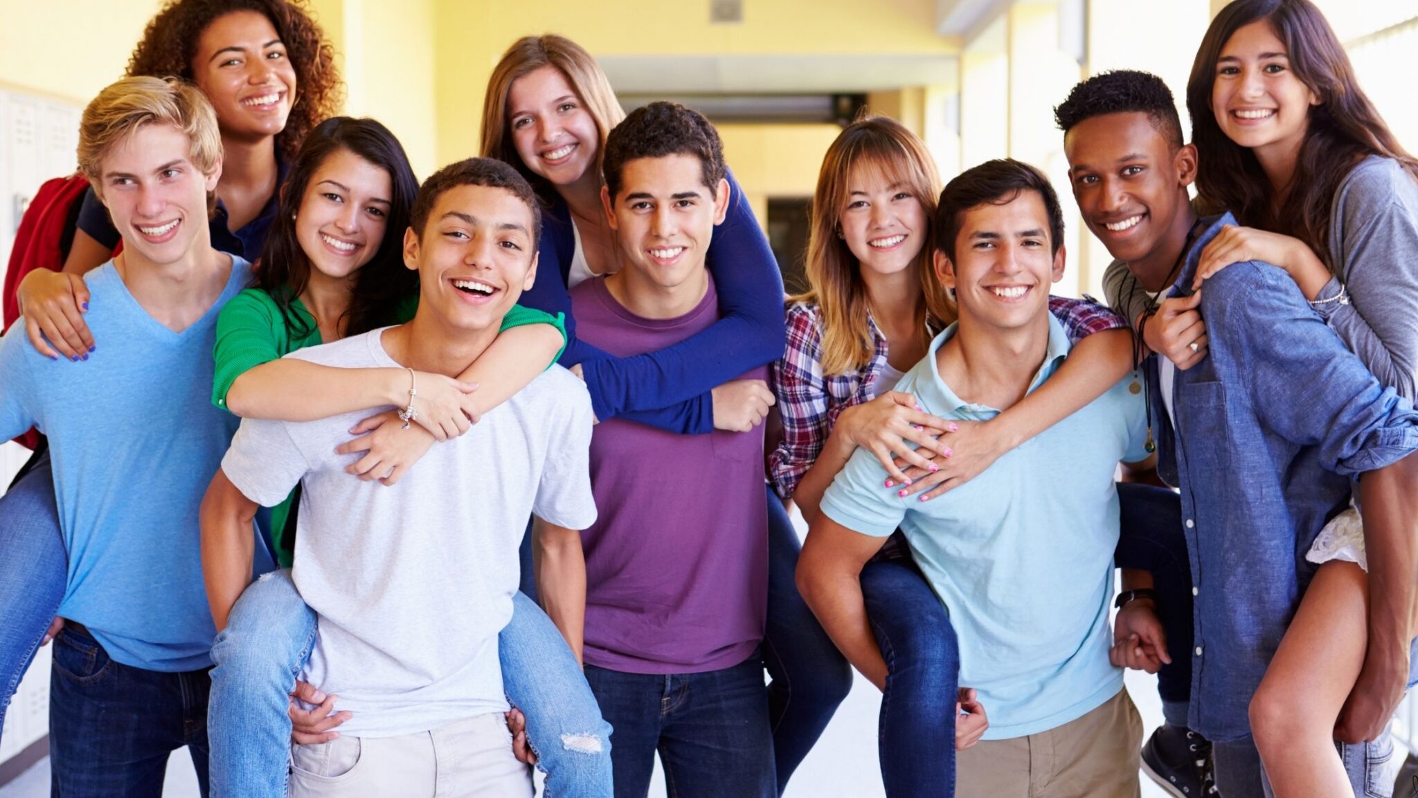 group of diverse teens gathered together and smiling for the camera